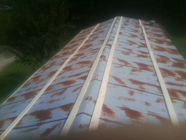 Rusted metal roof panels with new wood purlins before replacement — Storm Damage Roof Repair in Paullina by Roofing Brothers